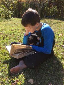 boy reading outside on a sunny day