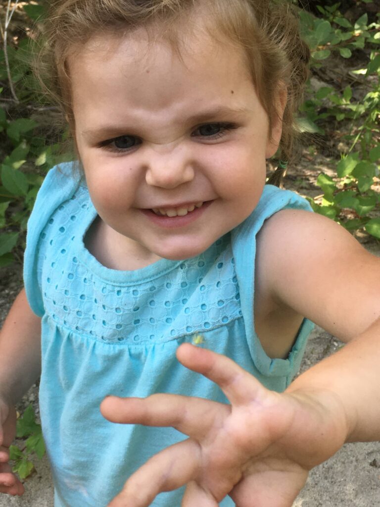 little girl making a face about a bug on her finger