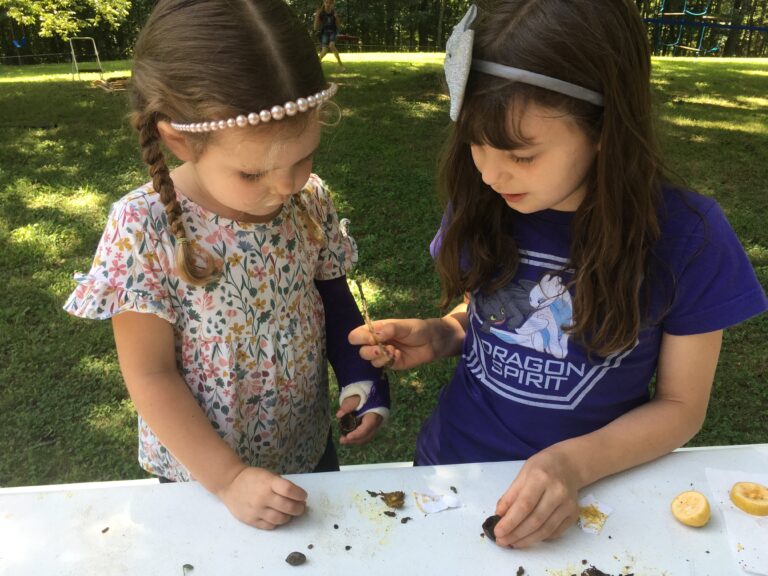 Two girls doing a homeschool science lesson outside