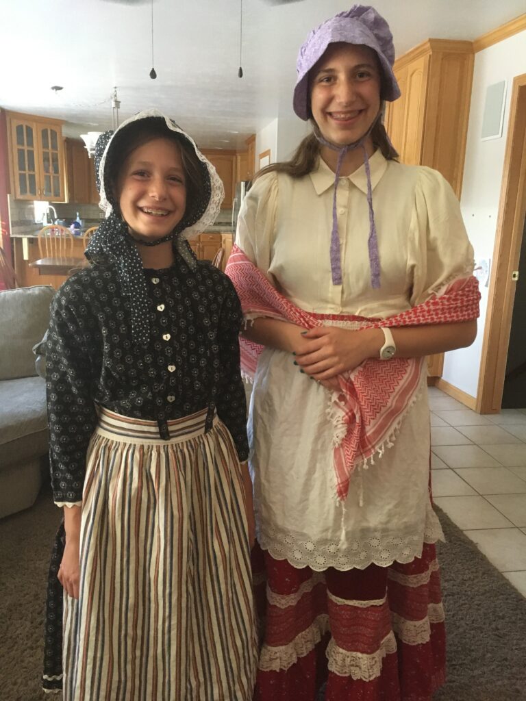 two girls dress up as pioneer in a memorable homeschool activity