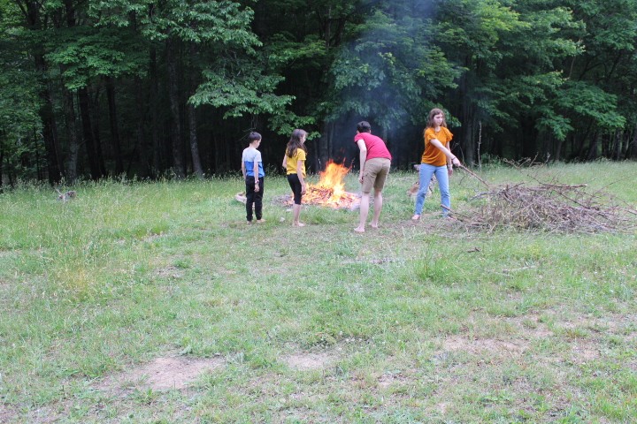 family burns branches in a bonfire