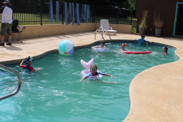 kids swimming in a backyard pool