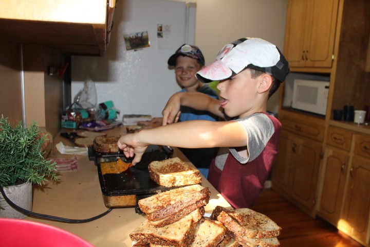 two boys making grilled cheese sandwiches