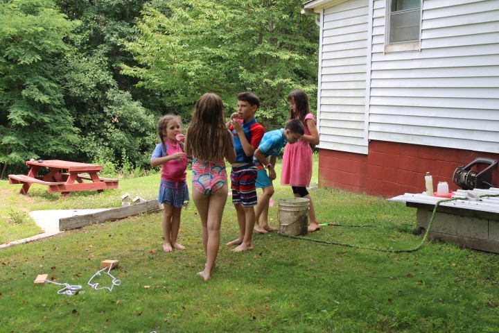 kids playing with water balloons in the yard