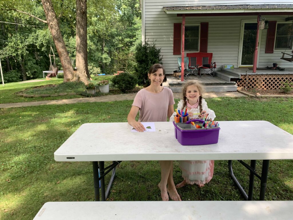 mom and daughter doing art on the picnic table