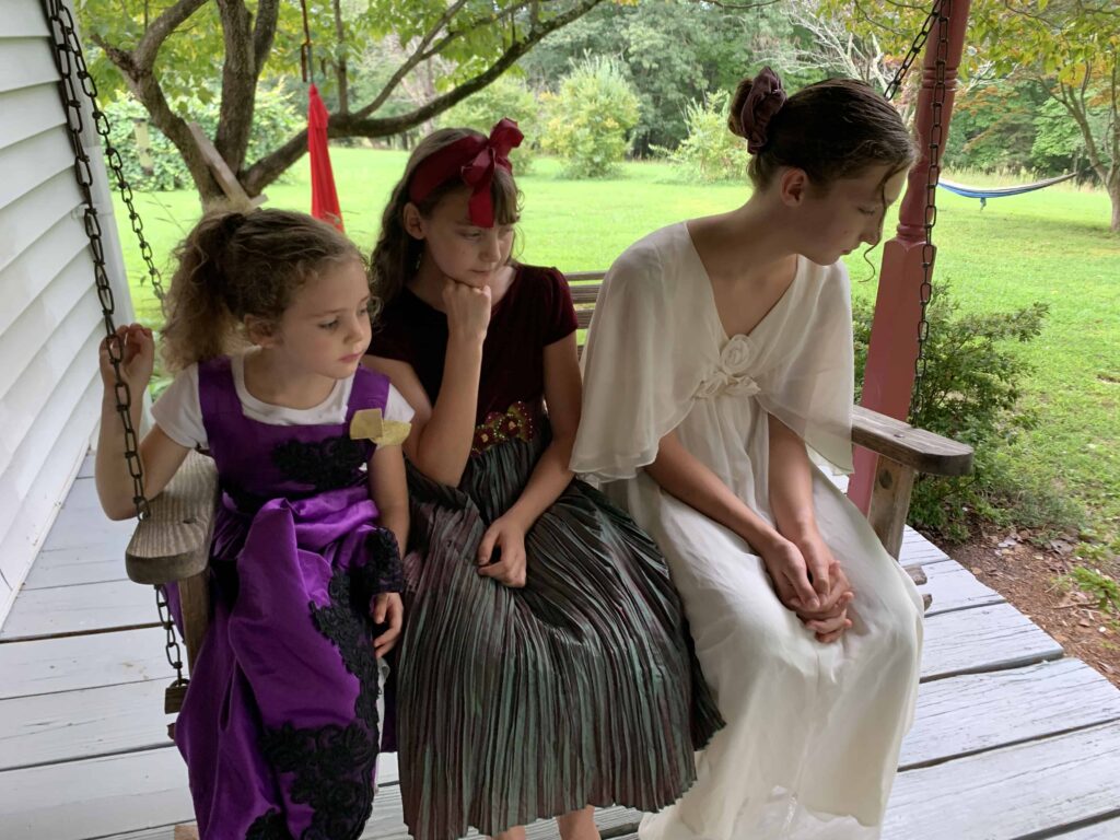 3 girls waiting for boys to bid on their picnic lunches like in Calpurnia Tate